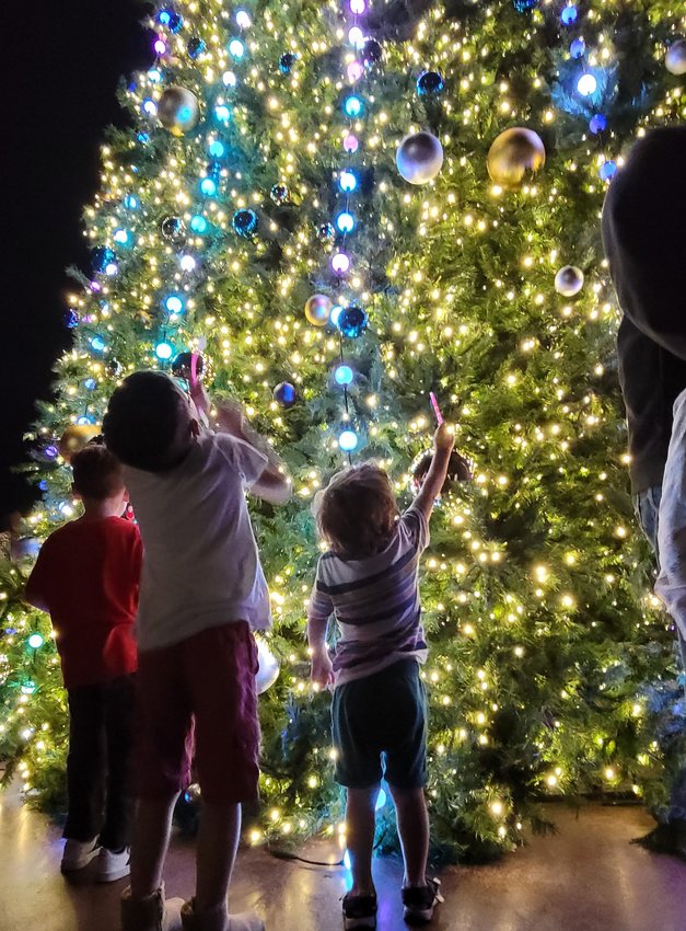 Leander residents take photos Friday at the tree lighting event held during the annual Leander Old Town Christmas Festival.