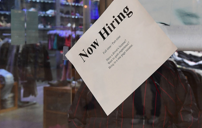 A &quot;Now Hiring&quot; sign is placed on the glass store front of a store in Montebello, California on Dec. 9, 2021. (Frederic J. Brown/AFP via Getty Images/TNS)