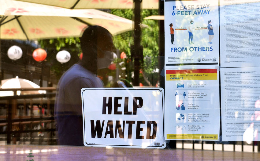 A &quot;Help Wanted&quot; sign is posted beside coronavirus safety guidelines in front of a restaurant in Los Angeles on May 28, 2021. (Frederic J. Brown/AFP/Getty Images/TNS)