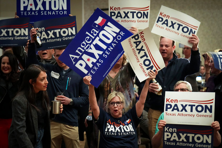 Supporters cheer and waves signs during a primary election night event for Texas Attorney General Ken Paxton and with his wife, State Sen. Angela Paxton, on Tuesday, March 1, 2022, in McKinney, Texas.