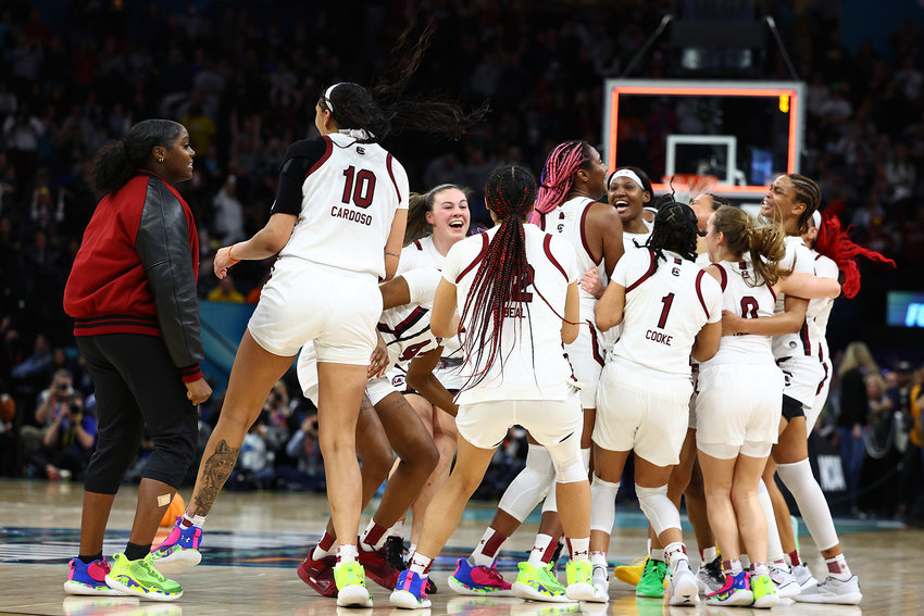 Kamilla Cardoso (10), Aliyah Boston (4) of the South Carolina Gamecocks, and Victaria Saxton (5) of the South Carolina Gamecocks celebrate with teammates after defeating the UConn Huskies 64-49 during the 2022 NCAA Women's Basketball Tournament National Championship game at Target Center on April 03, 2022, in Minneapolis, Minnesota. (Elsa/Getty Images/TNS)