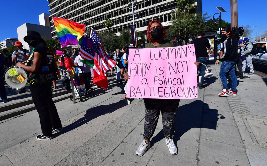 Activists hold a sign as they gather on International Women's Day to oppose the growing assault on abortion rights ahead of a U.S. Supreme Court decision in Dobbs v. Jackson Women's Health Organization, expected in late spring, March 8, 2022, in Los Angeles, California. (Frederic J. Brown/AFP/Getty Images/TNS)