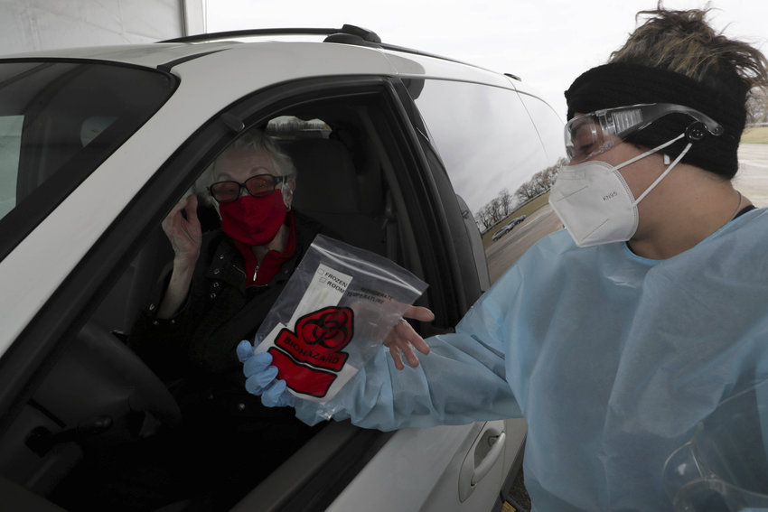 Angela Resto, right, helps Carol Pfister of Inverness with instructions for her self-test at the drive-thru COVID-19 testing and vaccination site on March 31, 2022, in Chicago. (Stacey Wescott/Chicago Tribune/TNS)