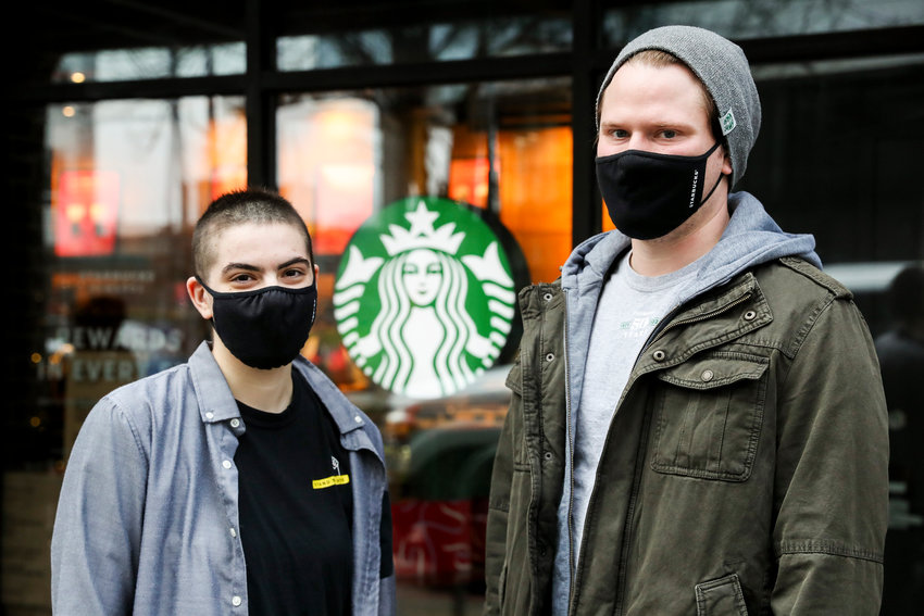 Rachel Ybarra, left, and Justin Ferguson, two members of the union organizing committee, outside their Starbucks in Seattle on Dec. 21, 2021. Starbucks workers around the country are attempting to unionize. (Amanda Snyder/Seattle Times/TNS)