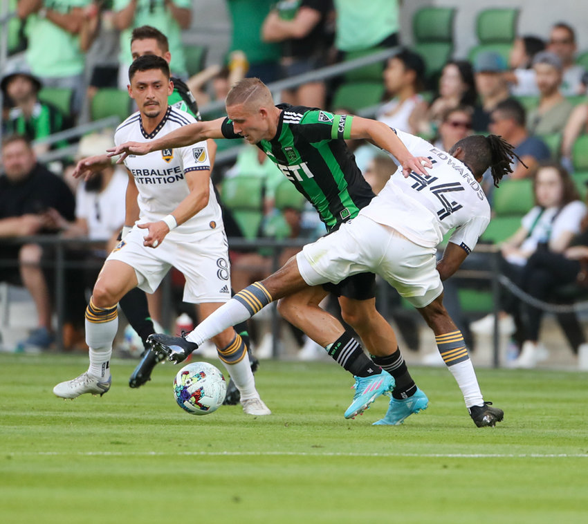 Austin FC midfielder Alexander Ring (8) tangles with Los Angeles Galaxy forward Raheem Edwards (44) as Galaxy midfielder Marco Delgado (8) looks on during a major league soccer match on May 8, 2022 in Austin, Texas.