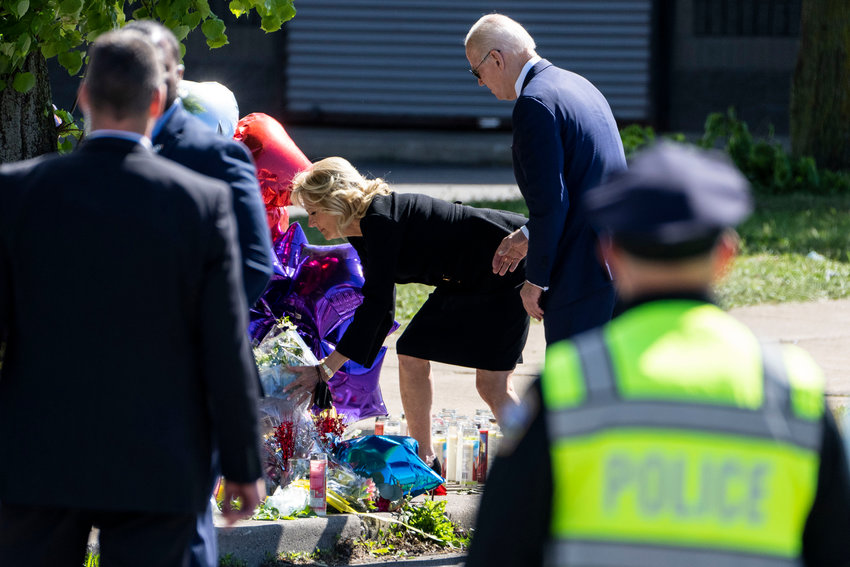 President Joe Biden stands back as first lady Dr. Jill Biden places flowers at a memorial just across the street of the Tops Friendly Market at Jefferson Avenue and Riley Street on Tuesday, May 17, 2022, in Buffalo, New York. The killing of 10 people in a historically Black neighborhood of Buffalo is being investigated as a hate crime and an act of &quot;racially motivated violent extremism,&quot; according to federal officials. (Kent Nishimura/Los Angeles Times/TNS)