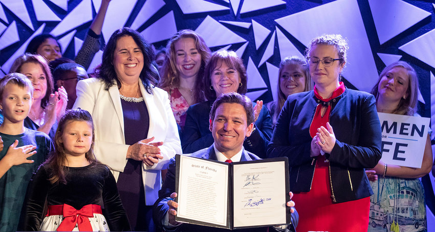 Governor Ron DeSantis holds up the newly signed bill that will ban most abortions in Florida after 15 weeks at a press conference in Kissimmee Orlando, Florida, Thursday, April 14, 2022. (Willie J. Allen Jr./Orlando Sentinel/TNS)