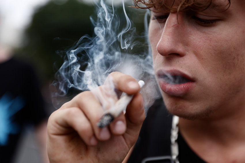 A participant smokes as activists demonstrating for the legalization of marijuana march in the annual Hemp Parade (Hanfparade) on Aug. 13, 2022 in Berlin.