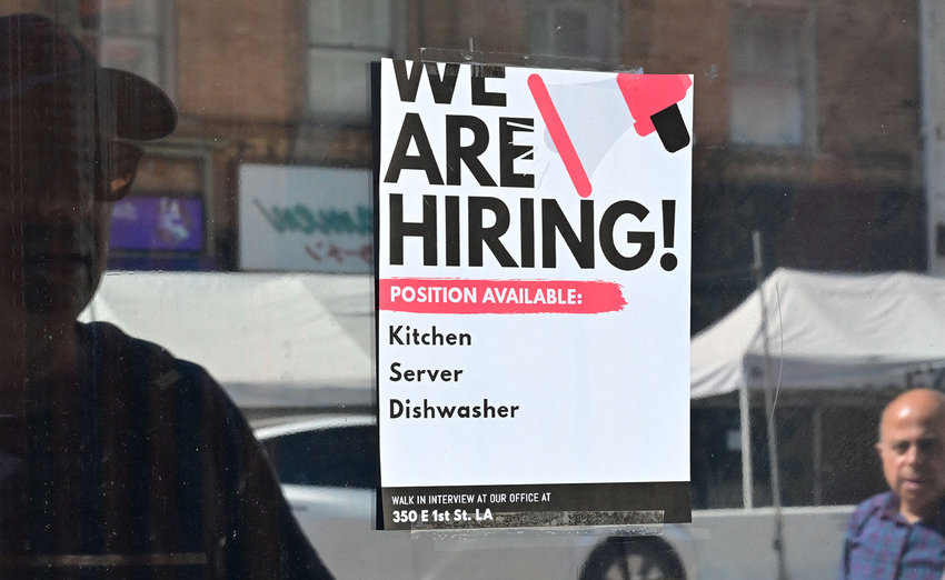 A &quot;We Are Hiring&quot; sign is posted in front of a restaurant in Los Angeles, California on Aug. 17, 2022.