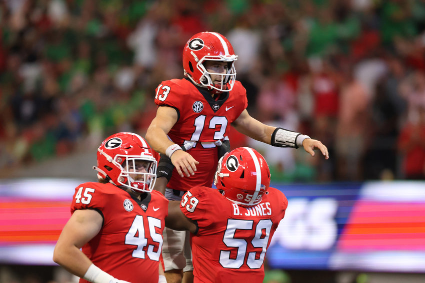 Georgia quarterback Stetson Bennett (13) celebrates with offensive lineman Broderick Jones (59) after a 4-yard touchdown pass during the second quarter against Oregon  in the Chick-fil-A Kickoff game at Mercedes Benz Stadium on Saturday, Sept. 3, 2022, in Atlanta. (Jason Getz/Atlanta Journal-Constitution/TNS)