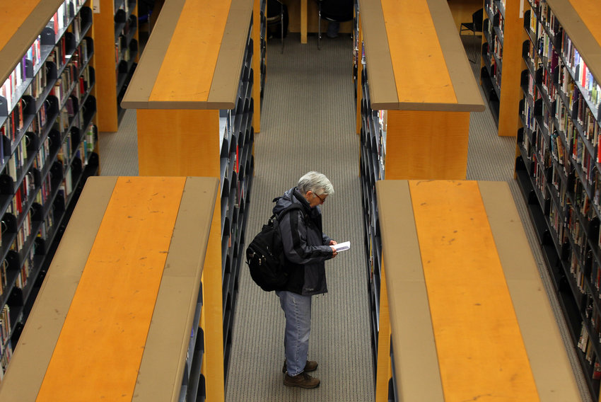 A library patron looks at a book at the main branch of the San Francisco Public Library on Jan. 11, 2011, in San Francisco. Librarians and their legislative allies in several states are pushing publishers of electronic books to lower their prices and ease licensing terms.