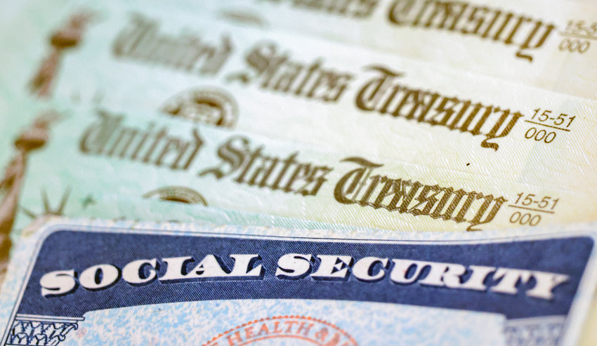 In this photo illustration, a Social Security card sits alongside checks from the U.S. Treasury on October 14, 2021, in Washington, DC. Social Security beneficiaries will receive 8.7% cost of living adjustment for 2023.
