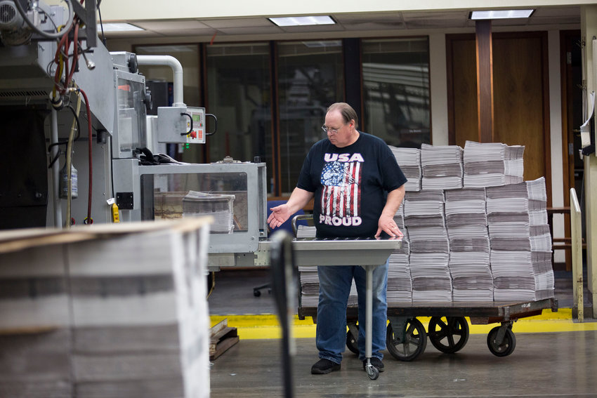 An employee bundles stacks of freshly printed newspapers at the Columbian newspaper on April 18, 2018, in Vancouver, Washington.