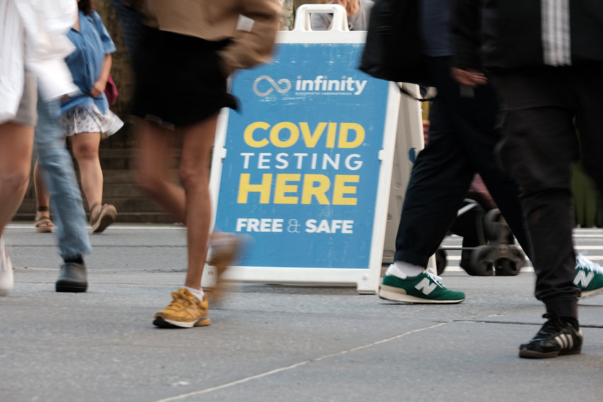 People walk past a COVID-19 testing site on May 17, 2022, in New York.
