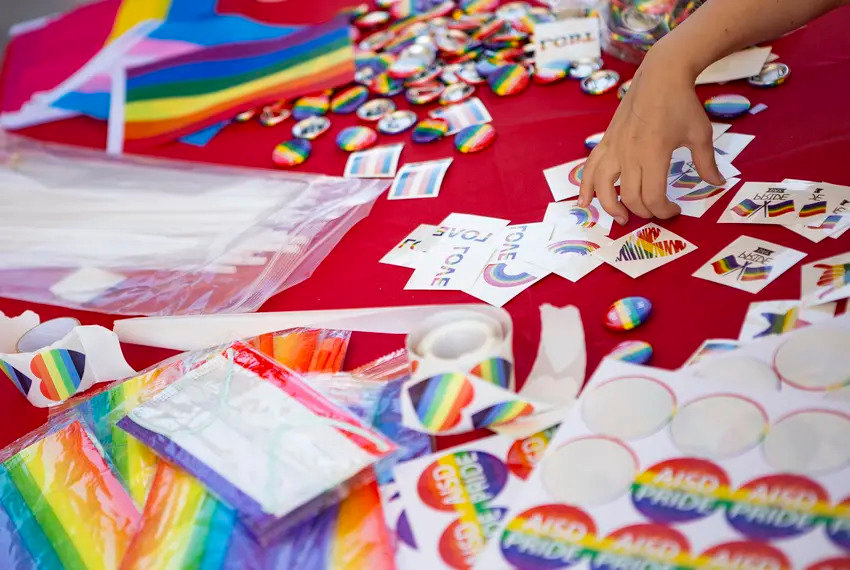 Pride flags, pronoun buttons and other merchandise are available at an Austin school district Pride event at Eastside Early College High School last year.