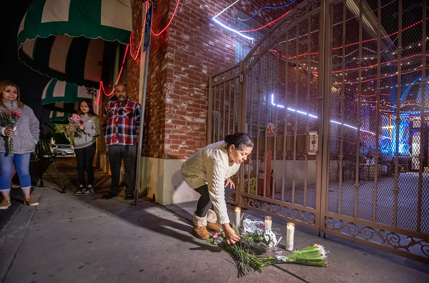 After police tape was taken down, people line up to place flowers at the entrance to the Star Ballroom Dance Studio in Monterey Park, where 10 people were killed and 10 were wounded.