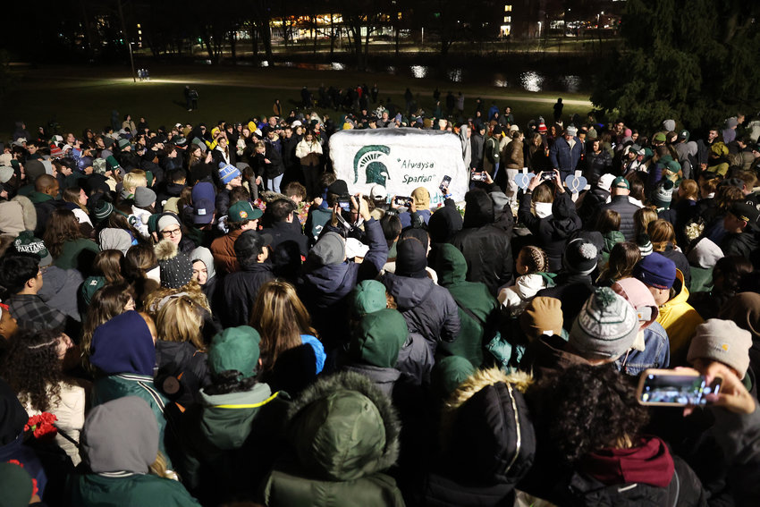 Students, faculty and others in the community attend a vigil on the campus of Michigan State University following a shooting on campus Feb. 13, when a gunman opened fire on campus, killing three students and critically wounding five others. The gunman shot himself a short time later after a confrontation with police.