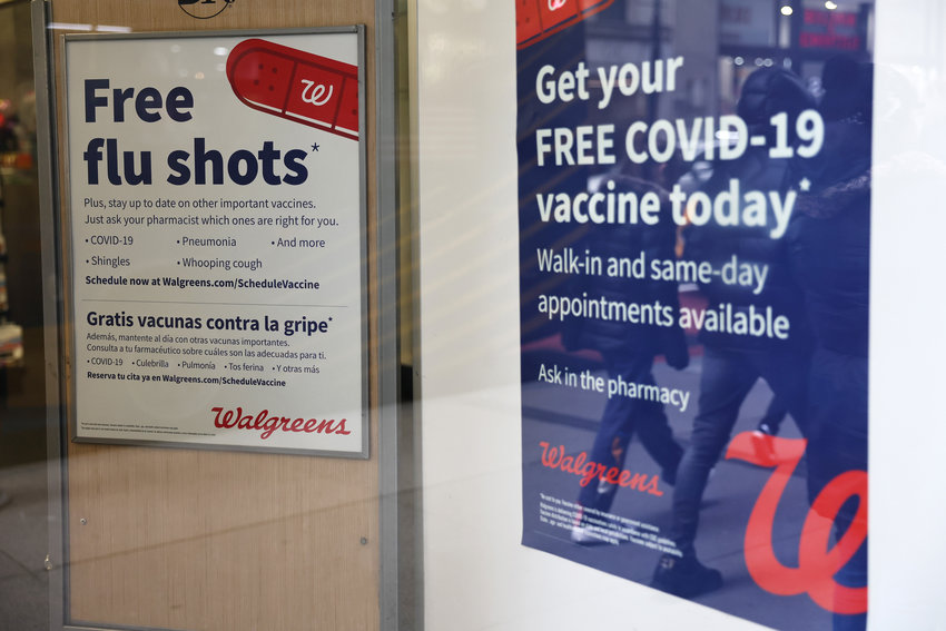 In this file photo, flu and coronavirus (COVID-19) vaccine signage at a New York drug store earlier this year.