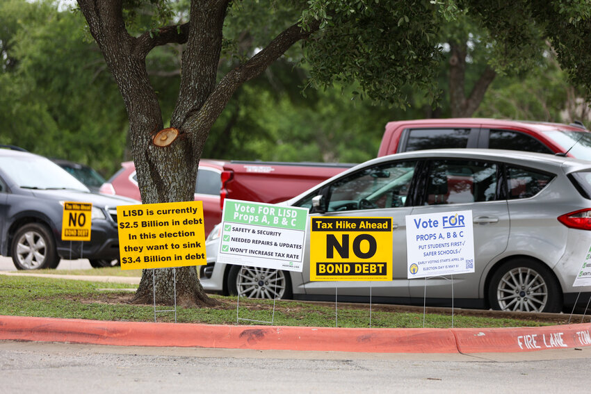 Signs supporting and opposed to Leander ISD&acirc;??s bond proposition for the May 6 election are visible on the first day of early voting, April 24, 2023, outside the Cedar Park Public Library polling place.