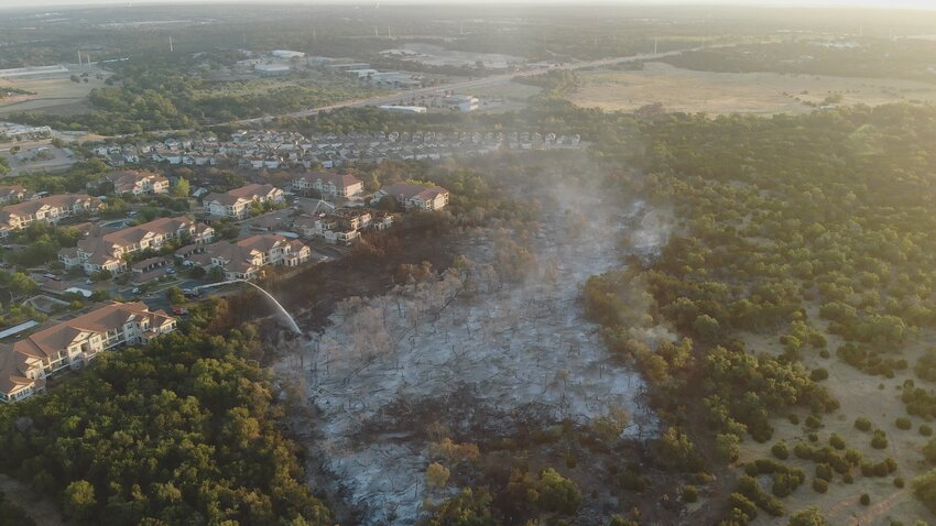 An aerial photograph taken Wednesday, Aug. 9, 2023, shows the extent of the massive grass fire along  Parmer Lane that totally destroyed one apartment building and damaged two other apartment buildings at the Bexley at Silverado, located at 12820 West Parmer Lane in Cedar Park.
