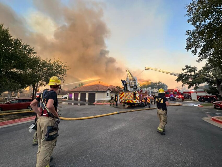 Firefighters battle a structure fire Tuesday, Aug. 8, 2023, resulting from a 50-acre grass fire along  Parmer Lane that totally destroyed one apartment building and damaged two other apartment buildings at the Bexley at Silverado, located at 12820 West Parmer Lane in Cedar Park.