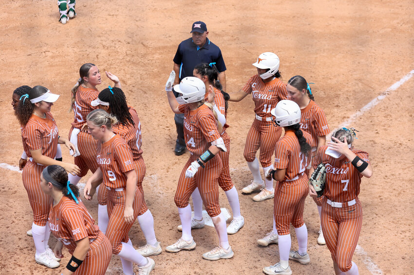 The Texas Longhorns meet Reese Atwood (14) at home plate after a home run in the fourth inning of a Big 12 Conference softball game between Texas and Baylor on April 14, 2024 in Austin.