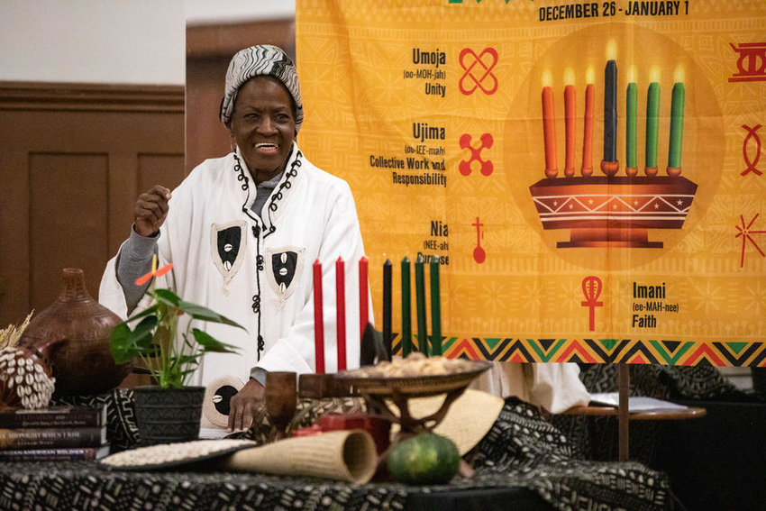 Kbibii Monié dances to African drumming and dancing during Northwest African American Museum’s Kwanzaa celebration at Washington Hall on Thursday, Dec. 29, 2022. During the event, Monié recited the libation statement called “Tamshi la Tambiko,” during which time water from the communal cup is poured out in memory of loved ones who have passed away. (Amanda Snyder/Crosscut)
