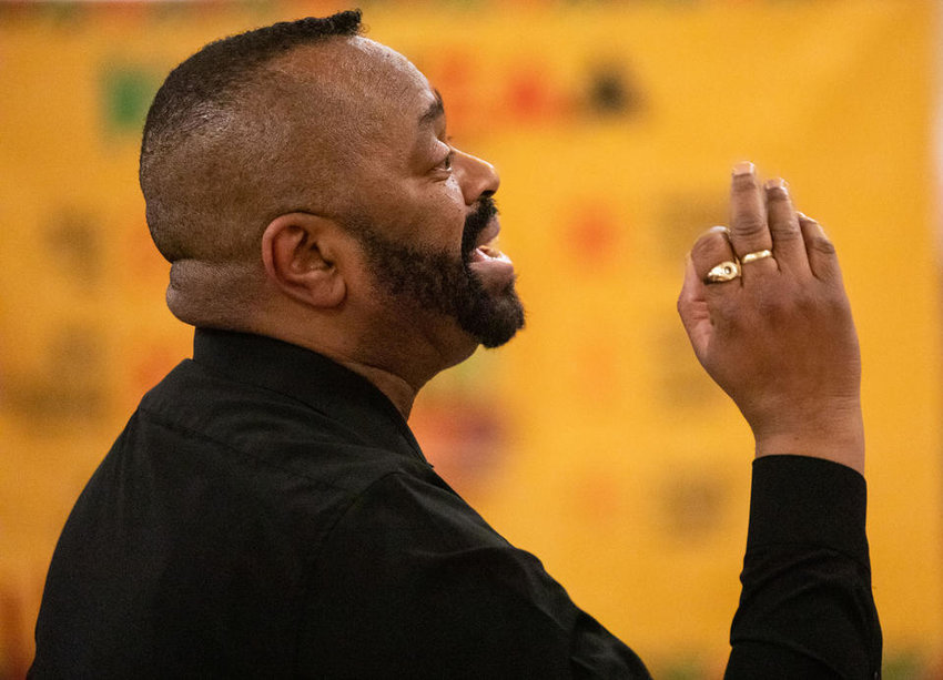 Kenya Leger, African American cultural ensemble’s conductor, leads the group during the Kwanzaa celebration at Washington Hall on Thursday, Dec. 29, 2022. (Amanda Snyder/Crosscut)
