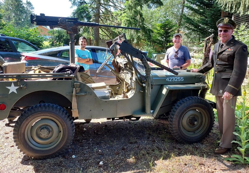 Dave Gaston, right, wearing a family WWII Class 'A' Army Air Corps uniform, as he shares his WWII-era jeep. Behind left is Rishi Sharma and behind right, Roger Schoessel. July 3, 2023.