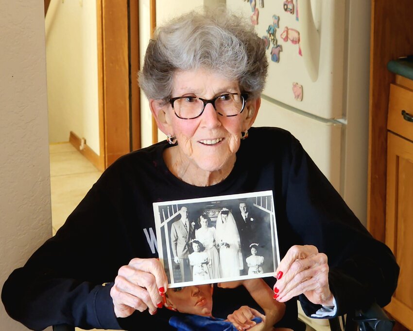 Doris Bier holds a photo of her wedding, complete with the Japanese neighbors who were her flower girls. Doris deplored the treatment of US citizens of Japanese heritage during the war. July 3, 2023.