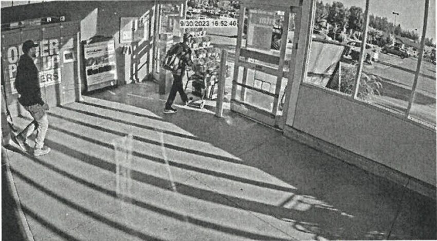 A surveillance camera still of the suspect leaving the store with a cart of unpaid merchandise.