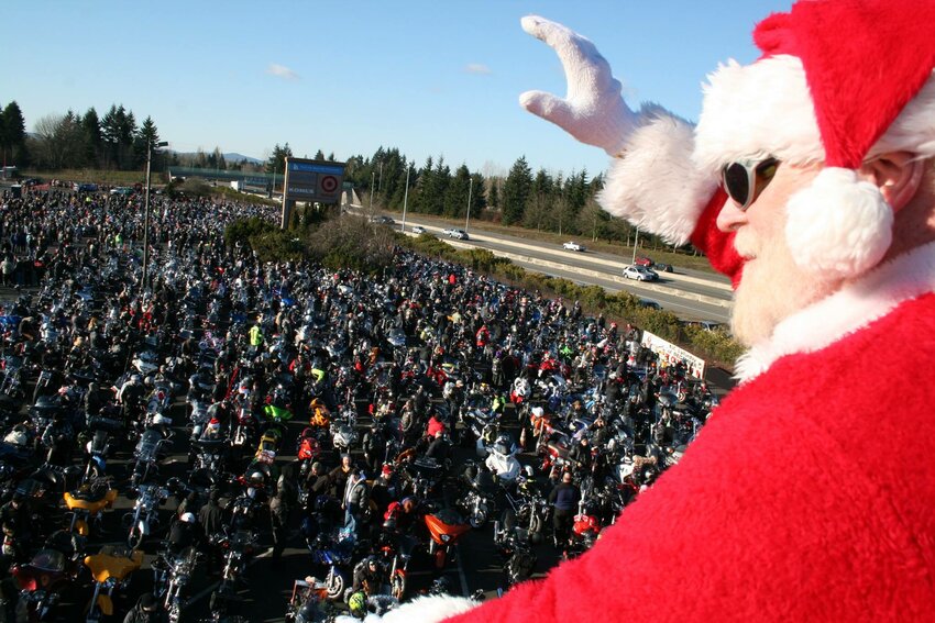 Santa in front of many motorcycles parked for the Olympia Toy Run