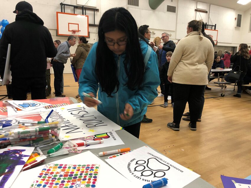 Vanessa Cruz Matias, a student attending Madison Elementary School, touches up her sign supporting her keeping her school open at the meeting held there on January 5, 2024.