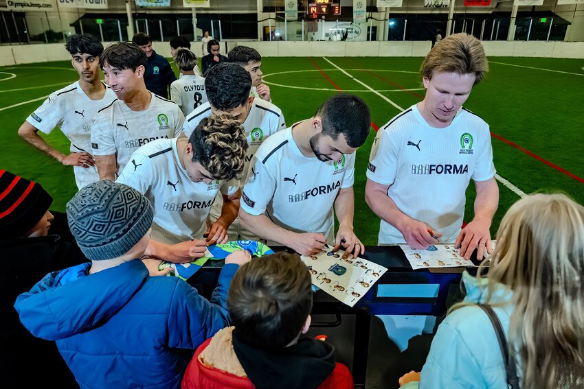 Oly Town FC's arena soccer players engage with fans after the match.