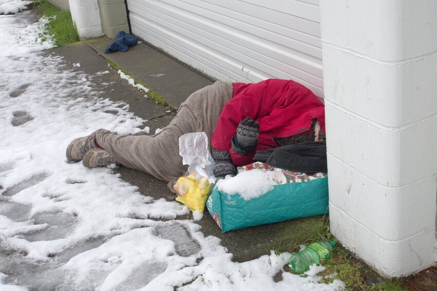 Snow on the Pillow:  A homeless man sleeps in the snow next to a warehouse located on Thurston Avenue NE.