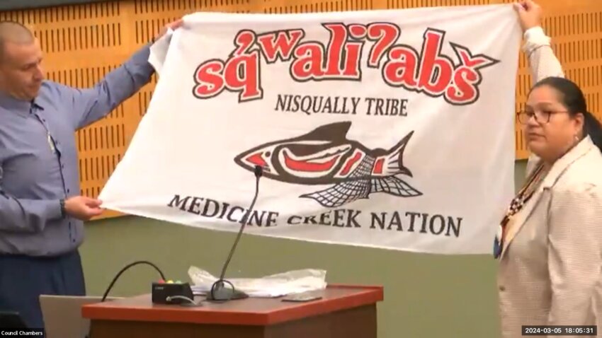 Nisqually Tribe Council Chairman Willie Frank III and Vice Chair Antonette Squally donated a flag that shows the Nisqually Tribe logo to the Olympia City Council during the proclamation of Billy Frank Jr. Day on Tuesday, March 5, 2024.