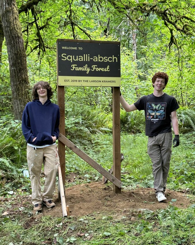 The youngest generation of the Larson-Kramer family is shown at the entrance to their family’s stewardship forest, which is adjacent to the proposed development.
