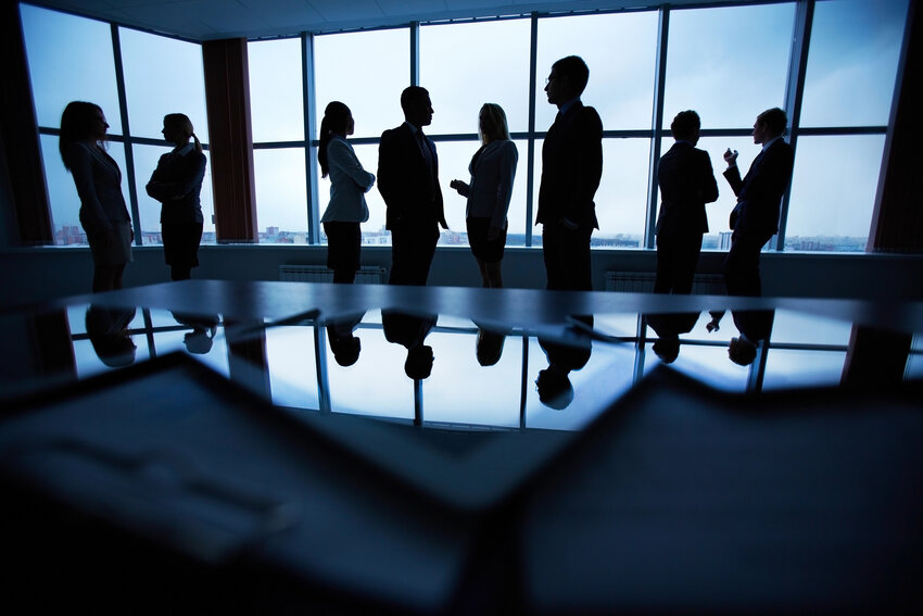 Silhouettes of a corporate group or board meeting