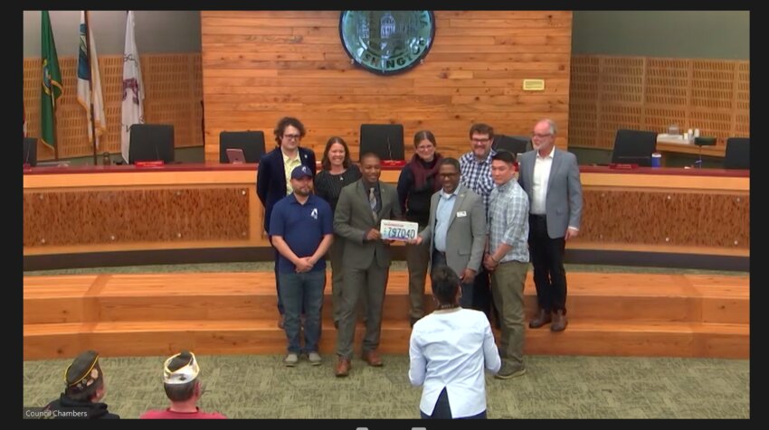 Olympia City Council posed with Fleet Operations supervisor Jaime Mastache and Solomon Gilbert from the Washington State Department of Veterans Affairs. The latter presented a suicide prevention emblem on Tuesday, April 16, 2024.