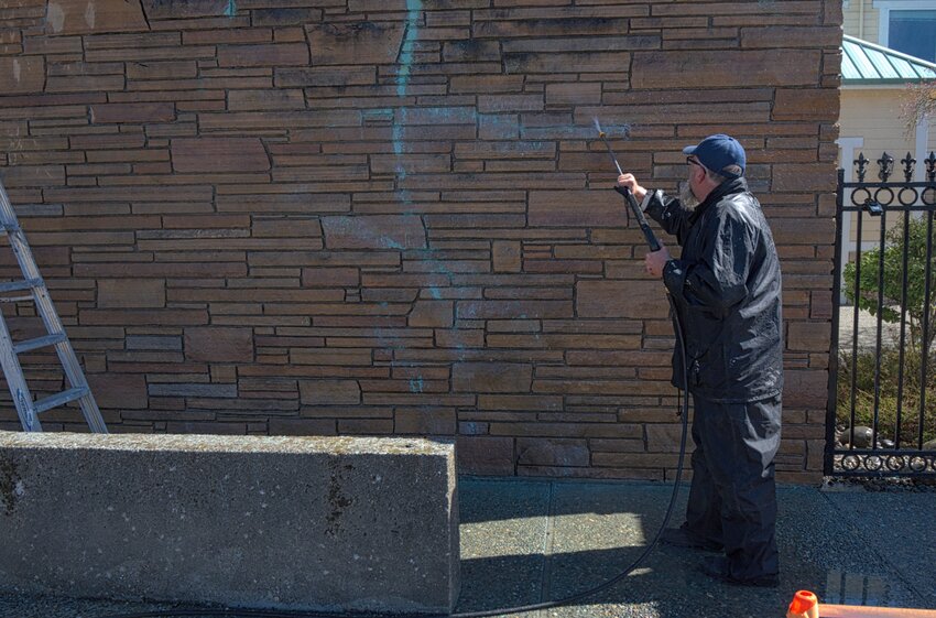 Eric Blue of Diversified Coatings removes graffiti from a downtown building.