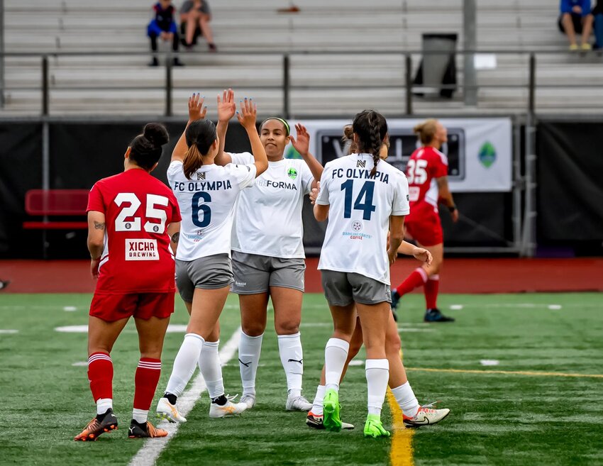 FC Olympia’s Yosue Suzuki (#6 in white) celebrates her goal with Ameera Hussen and Jojo Alonzo (#14). They continue to be on top of the USL W Northwest Division.