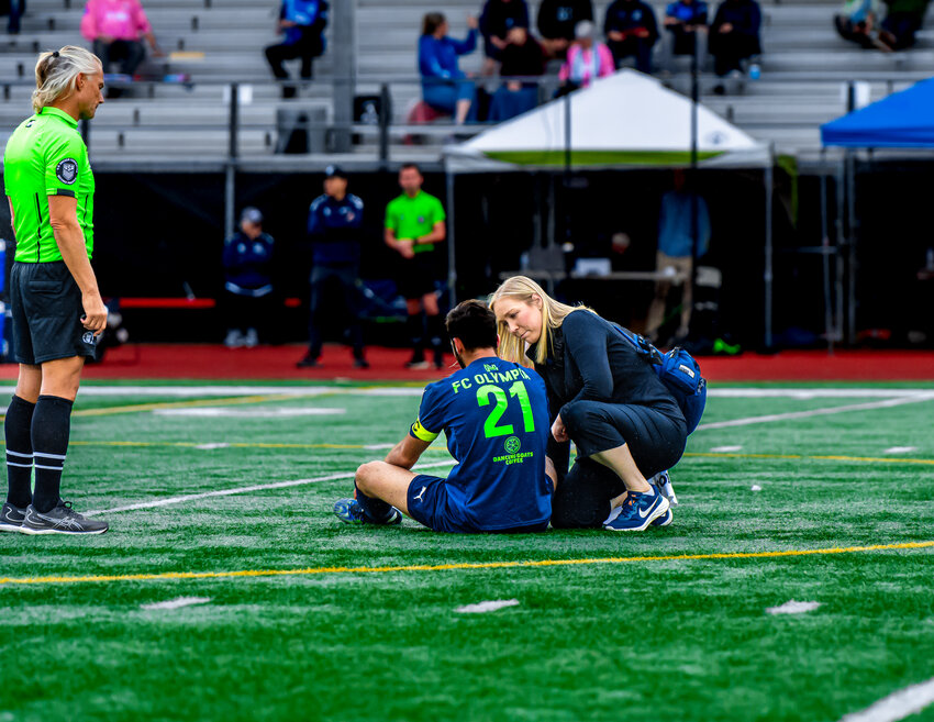 FC Olympia’s Andre Philibbosian was assisted by a medic after suffering a knock (Photo from C-Sharp Images