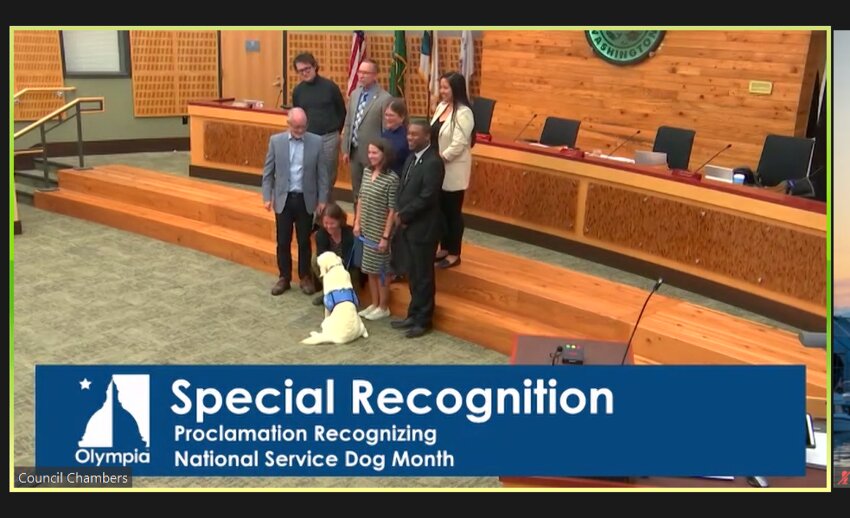 Olympia City Council members pose with Daiz for a photo op to commemorate the city's first proclamation of National Service Dog Month. 