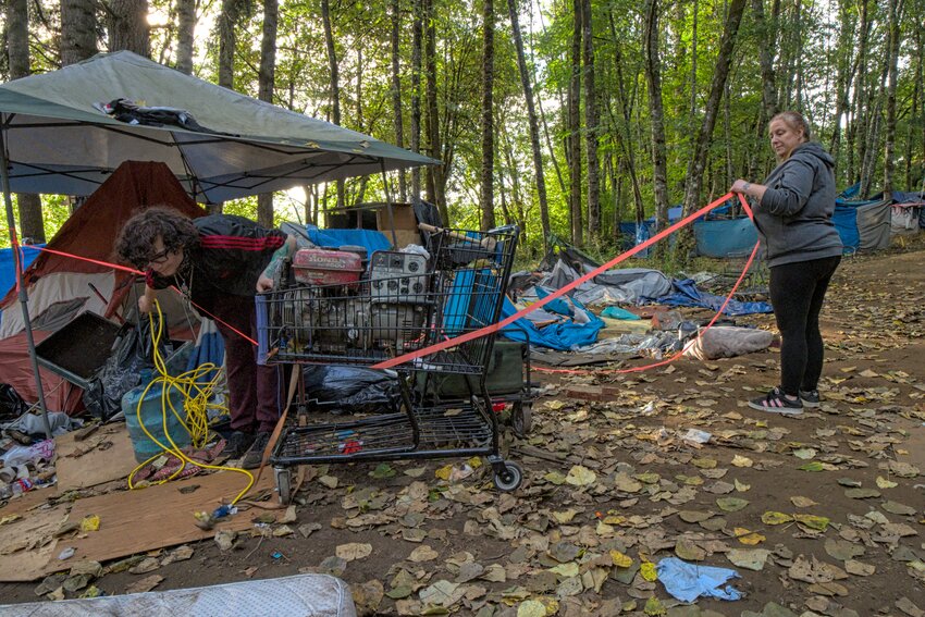 Two residents of The Jungle use tape to mark off items they did not want removed.