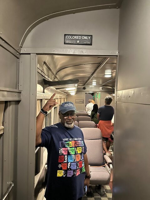 Jarvis points to the "Colored Only" sign in this segregated passenger rail car inside the National Museum of African American History & Culture.