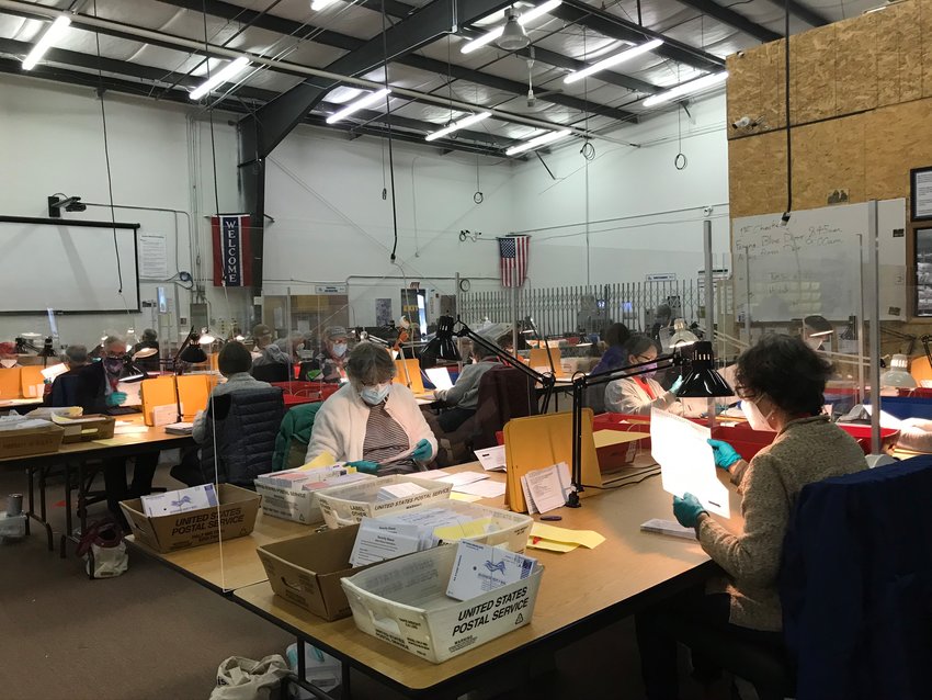 Elections workers examine ballots at the Ballot Processing Center in Tumwater on Friday, Oct. 30.