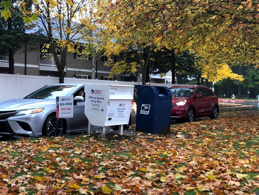 A driver deposits her ballot in the official drop box across the street from the U.S. Post Office in Lacey on Election Day last year.