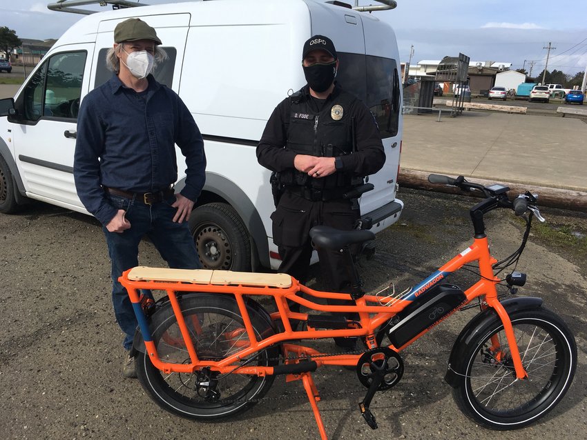 Kirk Trowbridge with Ocean Shores Police Officer Daniel Fode on Sat., Mar. 6, in Ocean Shores, just before they loaded Trowbridge's bike into his van for the trip home to Olympia.