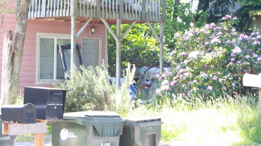 This is an image of the exterior of the house registered to C Davis showing some of the material that the city has cited him for in the yard.  May 14, 2021.