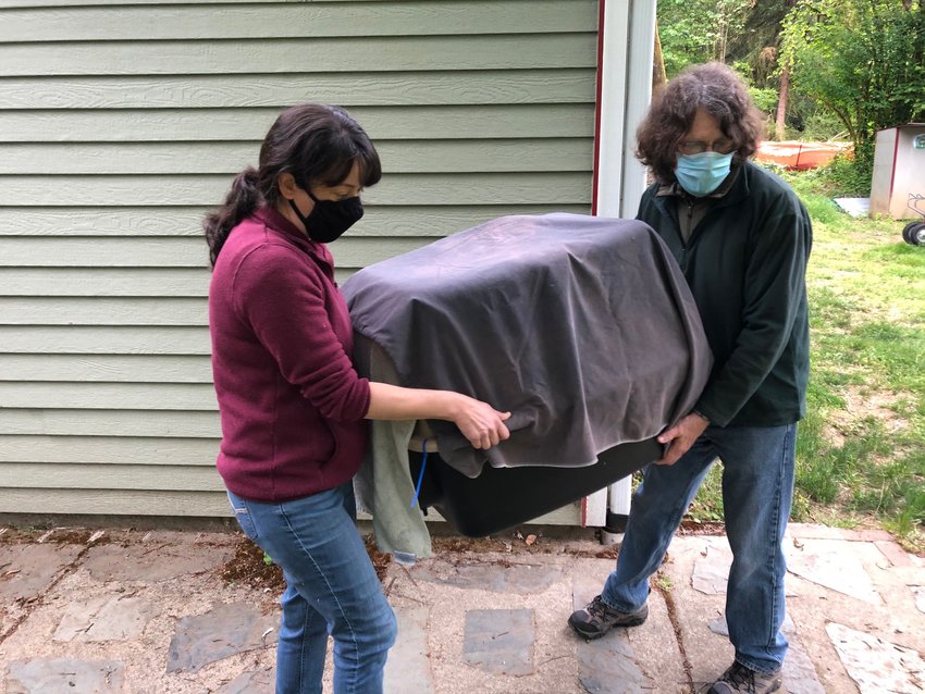 This sequence shows the bald eagle being carried from the vehicle in which it was transported back to the property where it was found, on Sun., May 23, 2021, just prior to its release. L-r, Stephanie Estrella, Mark Fleming.